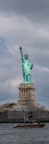 На фото изображена лодка где на фоне стоит статуя свободы