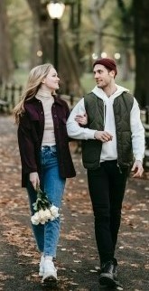 На фото парень с девушкой гуляют в парке и общаются