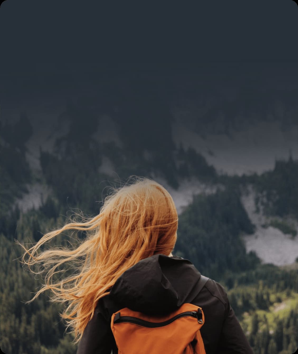 На фото девушка стоит на фоне горы