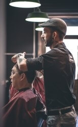 Фото, где в парикмахерской один мужчина подстригает другого мужчину